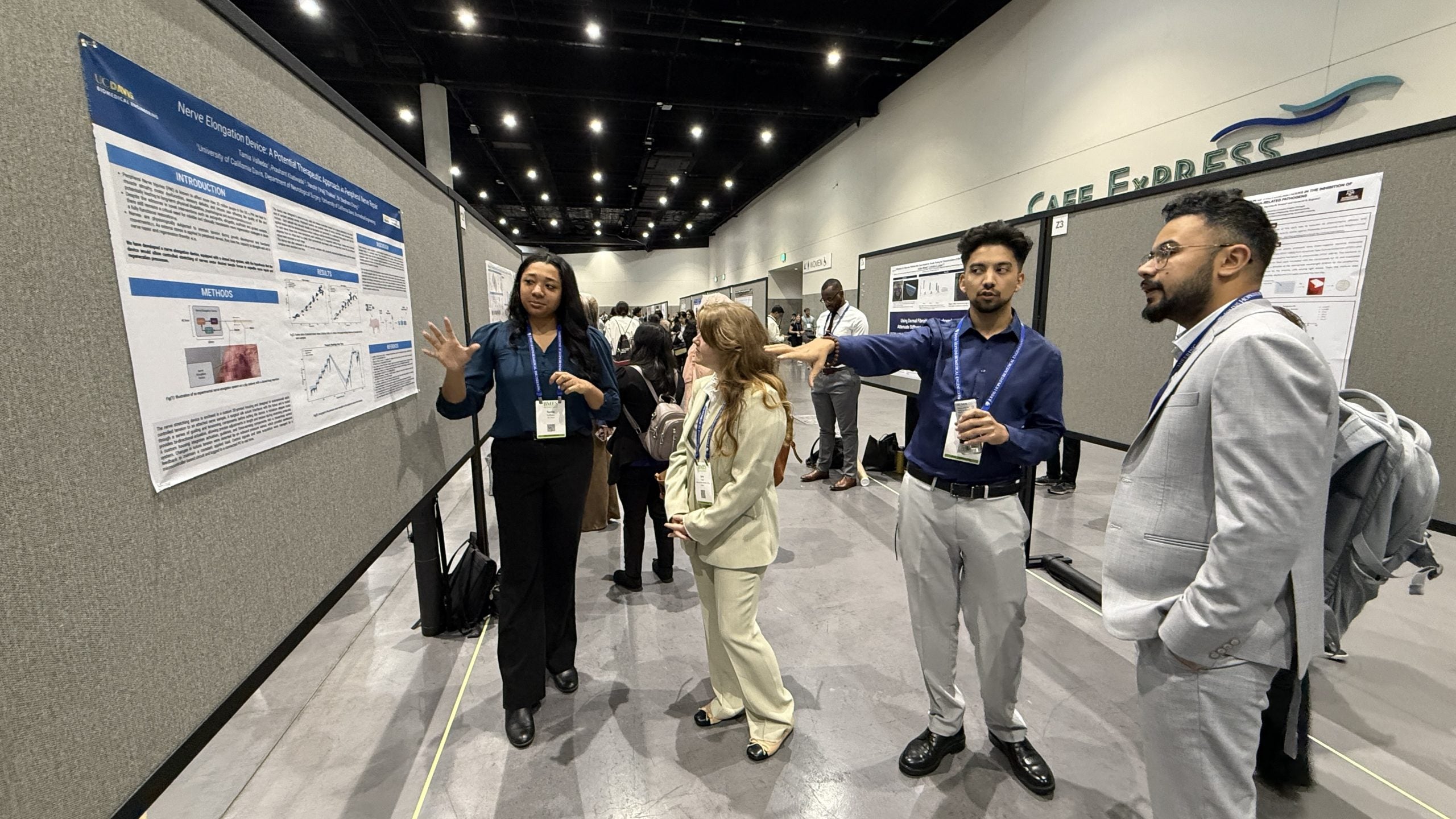 Tamia and Prashant present Nerve Elongation Device poster to conference attendees
