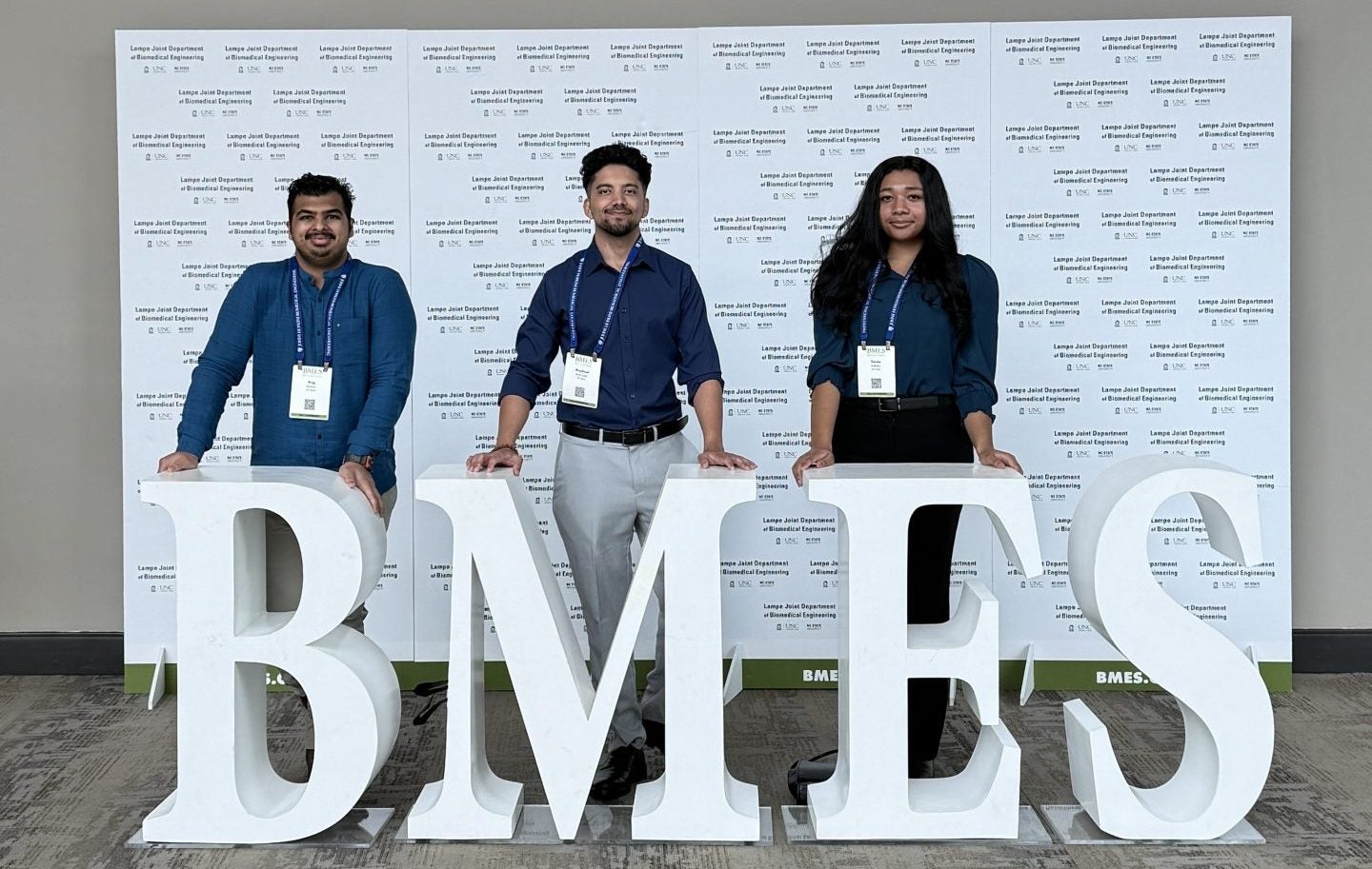 Vraj (left), Prashant (center), and Tamia (right) pose with BMES logo