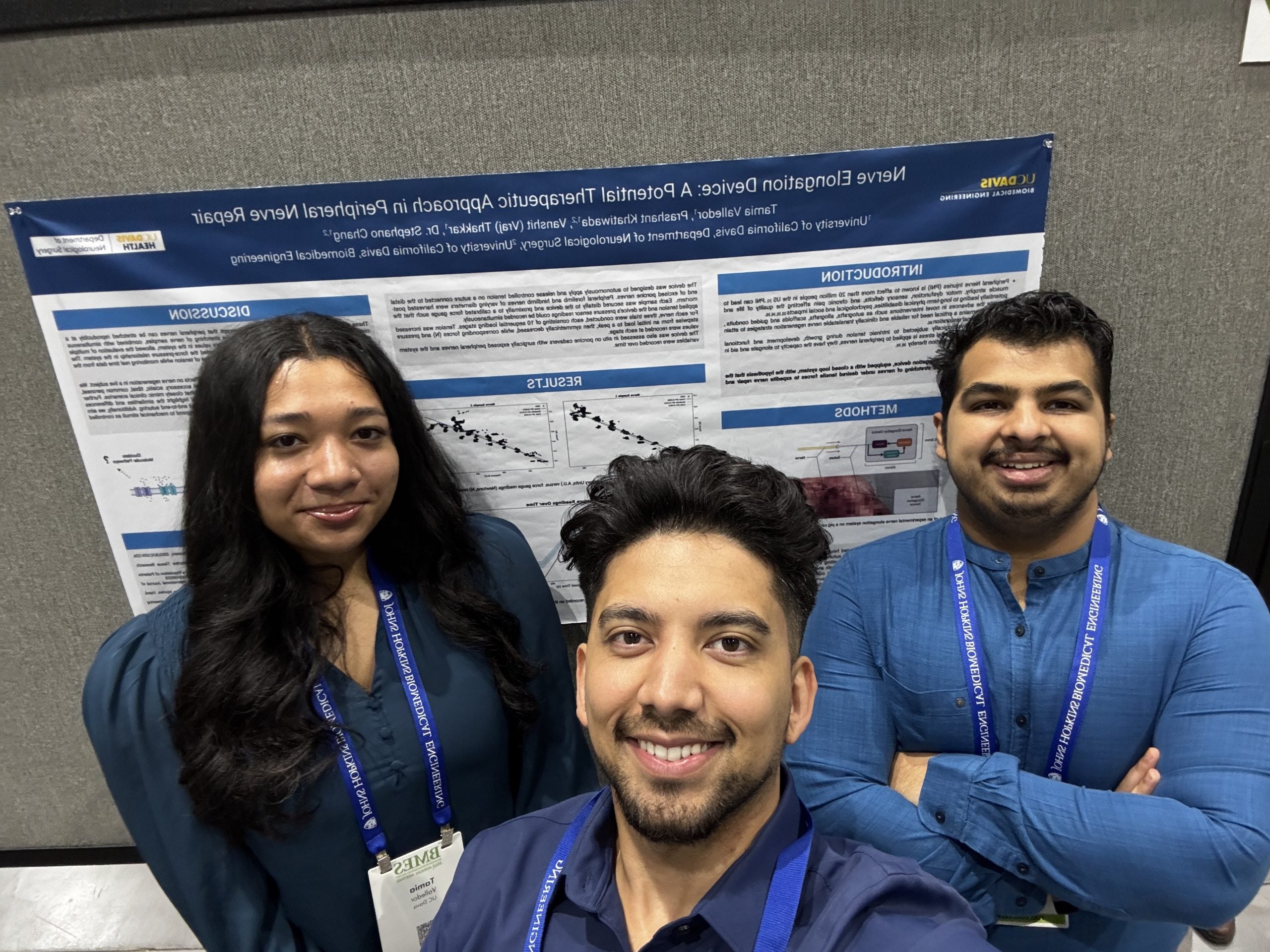 Vraj (left), Prashant (center), and Tamia (right) pose in front of Nerve Elongation Poster